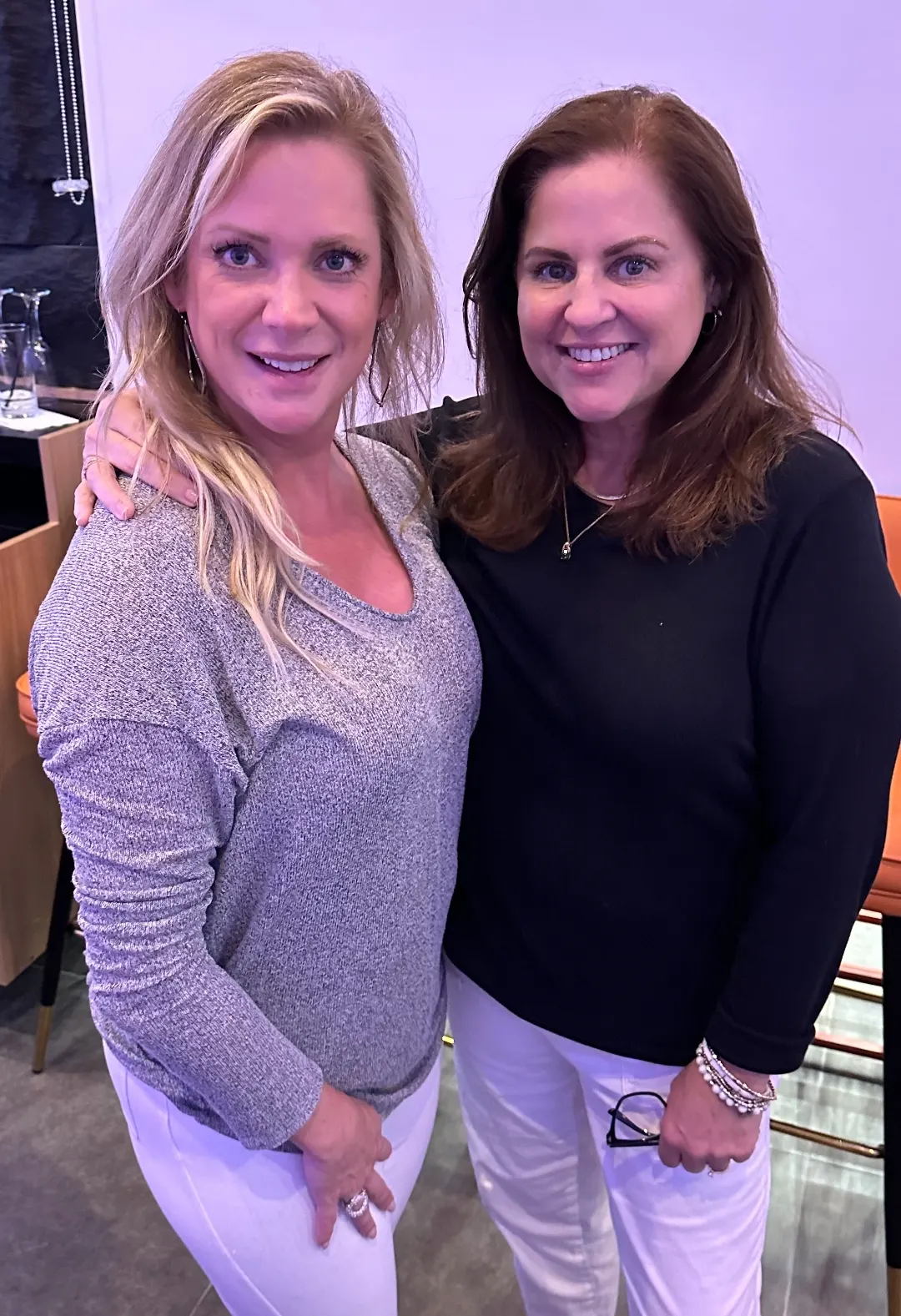 Two smiling members posing together at a networking event