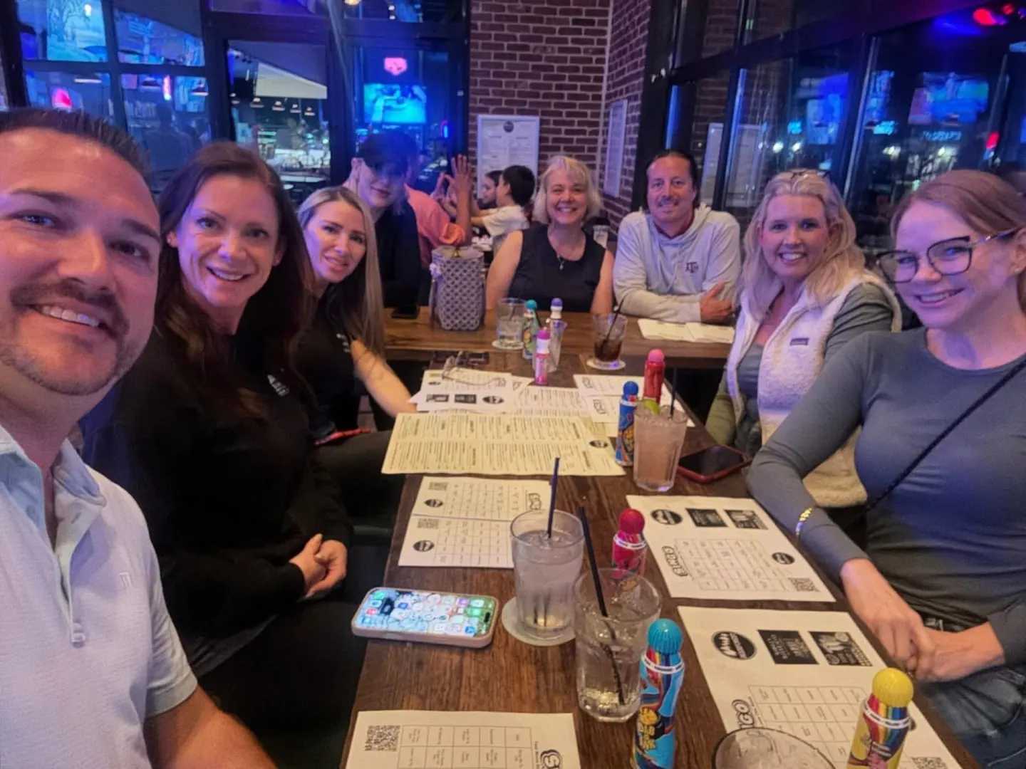 Members playing bingo and socializing around a table at a local restaurant